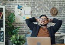 Estrés y dolor de espalda: qué se sabe y qué puedes hacer Trabajador hace una pausa y se mueve en su puesto de trabajo