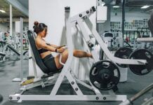 Ejercicios para la tendinopatía de Aquiles: progresión de carga y vuelta a correr Persona preparando un ejercicio de fuerza en un gimnasio