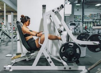 Ejercicios para la tendinopatía de Aquiles: progresión de carga y vuelta a correr Persona preparando un ejercicio de fuerza en un gimnasio