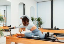 Pilates con máquinas o en suelo: diferencias y cómo elegir según tus objetivos Pilates Reformer con una persona entrenando sobre el carro de la máquina