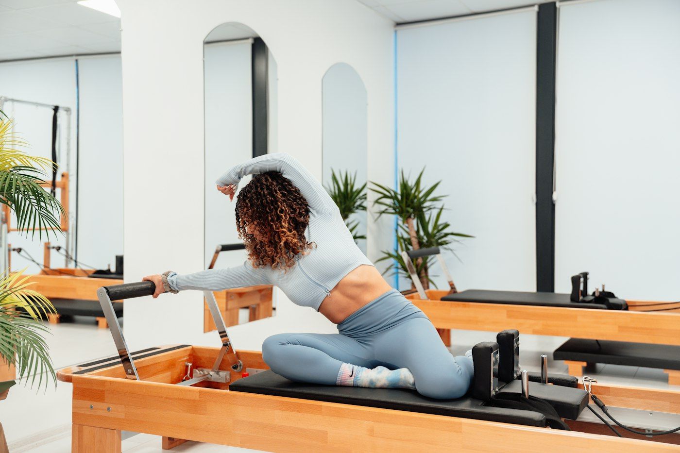 Pilates Reformer con una persona entrenando sobre el carro de la máquina
