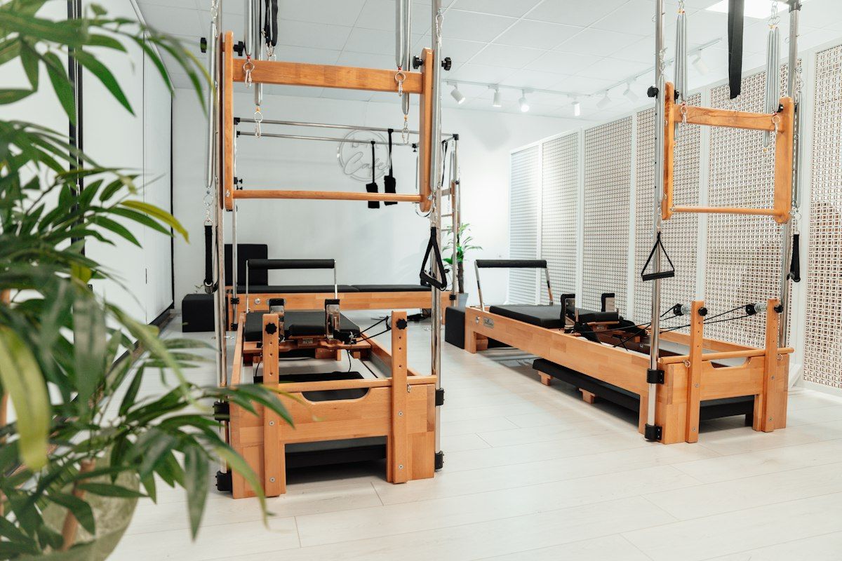 Sala equipada con máquinas de Pilates Reformer y carros deslizantes